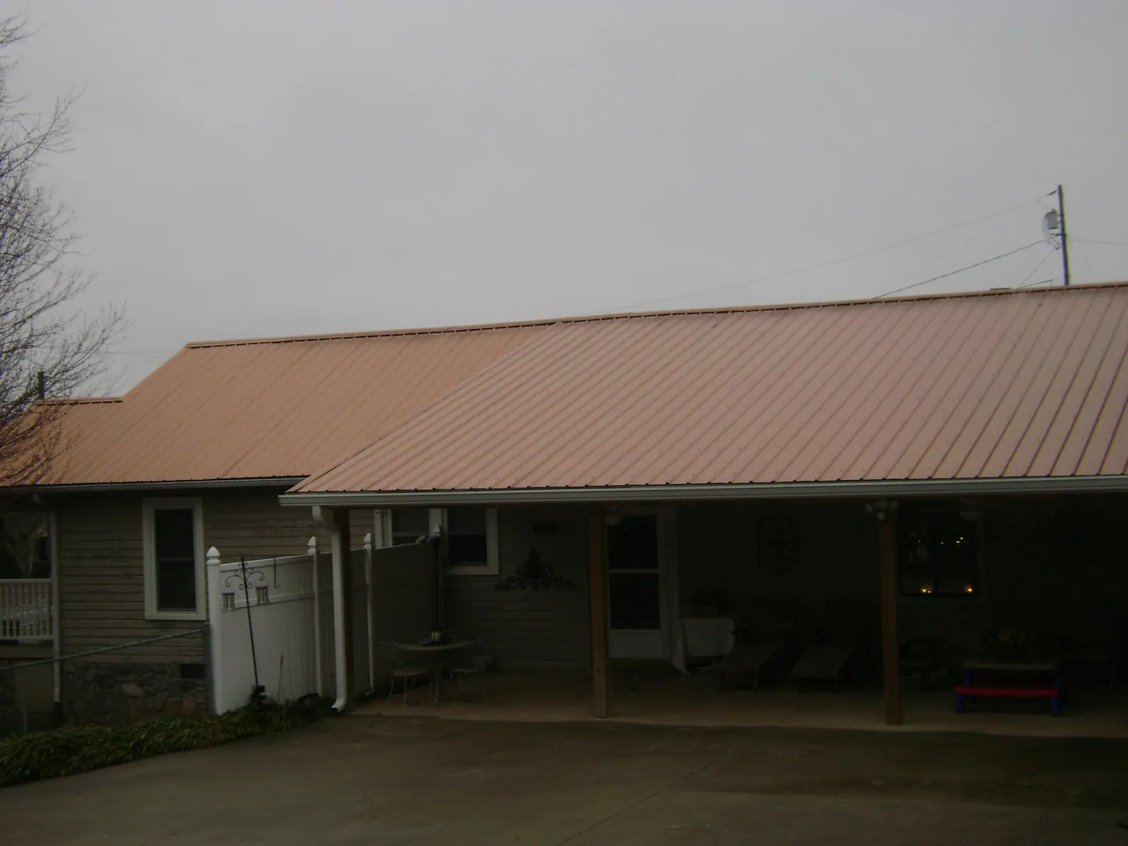 Copper toned metal roof over a wide covered patio in Albany